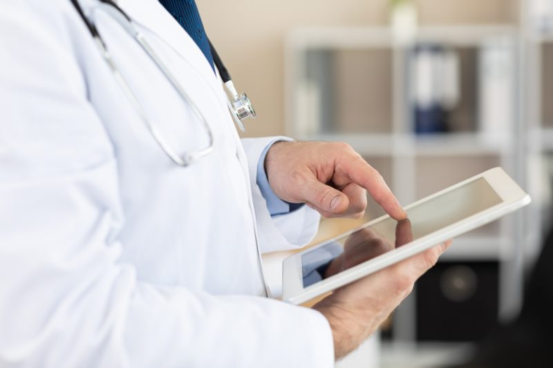 Doctor looking at a report on a tablet